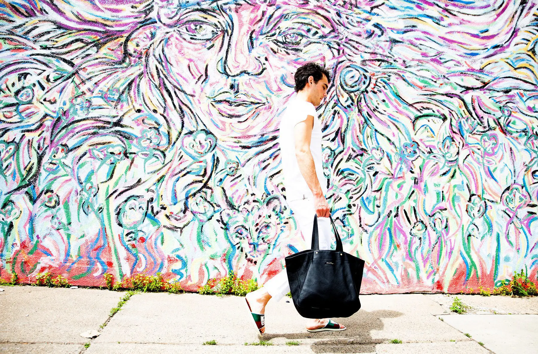 man walking down the street with fashion handbag. Copyright menswear market LLC 2024, men's clothing on consignment