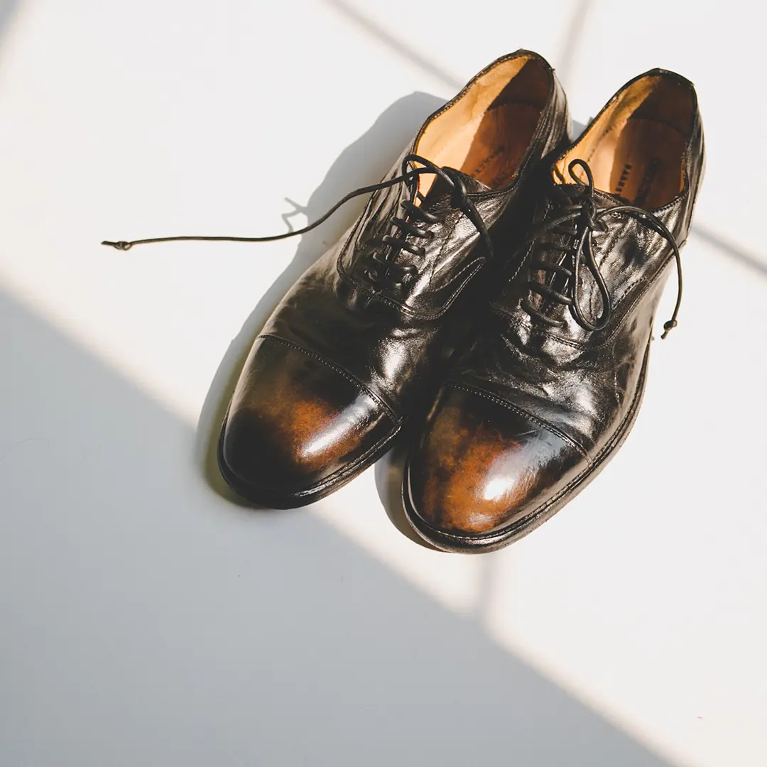 A pair of Italian designer shoes next to the window light.