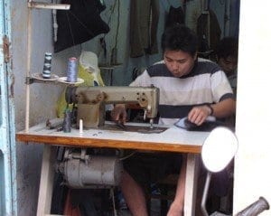 man sewing a garment in vietnam