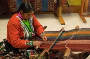 woman practicing traditional incan weaving at center for traditional textiles
