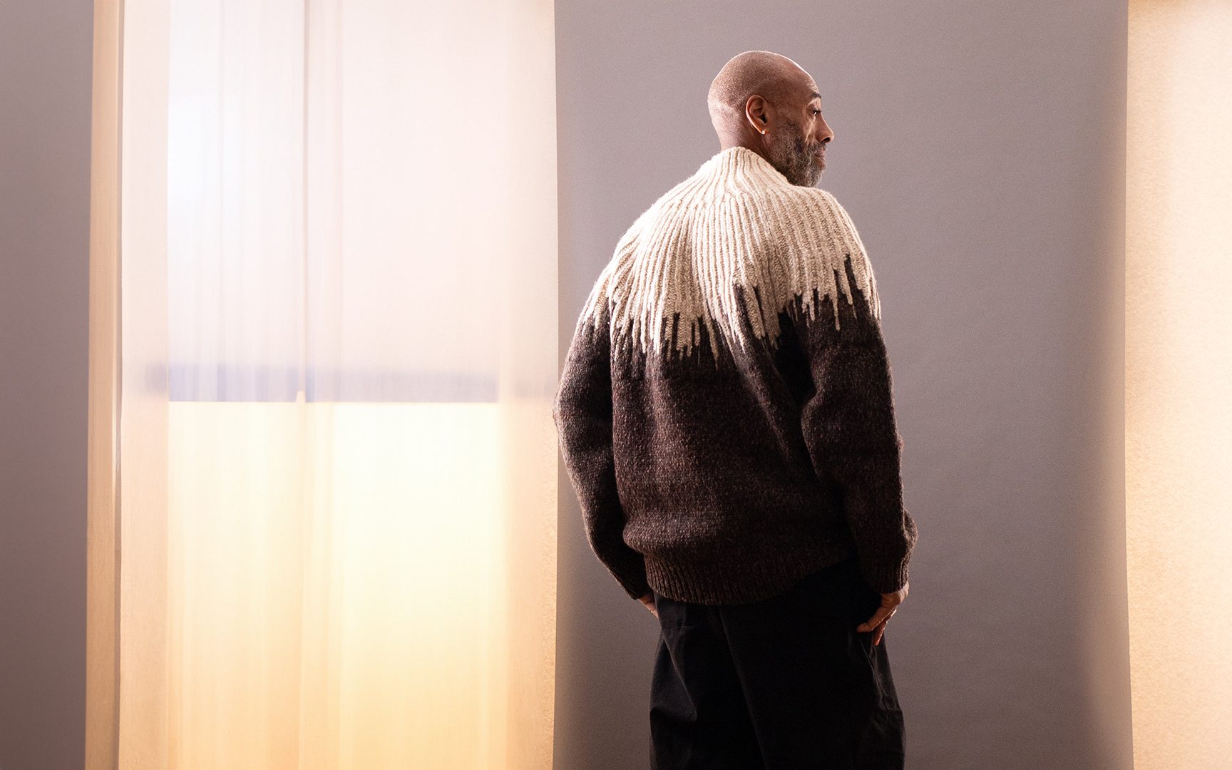 man wearing a designer sweater at menswear market, online consignment store for men's designer clothing