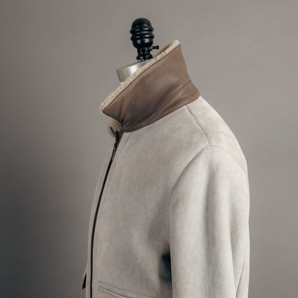 Under the collar of the AjMone Bayfield shearling jacket in stone gray